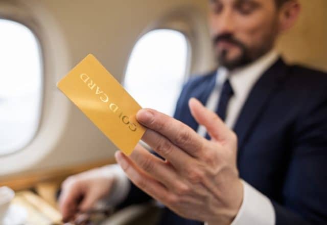 Wealthy flyer showing his Gold Card on a private jet