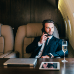 A man talks on a cellphone while sitting in a private jet