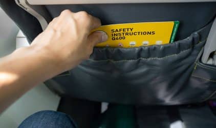 A person looking at an airline safety card