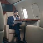 A businessman makes a call on a large business jet flight