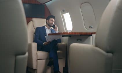 A businessman makes a call on a large business jet flight