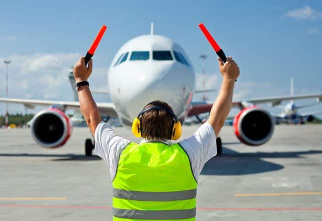 Ground crew signaling to a commercial aircraft