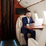 A man working on their laptop on a private jet