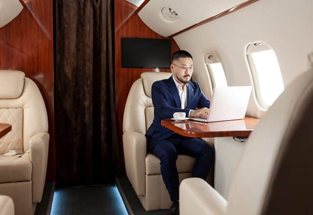 A man working on their laptop on a private jet