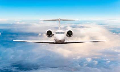 A private plane soars high above the clouds