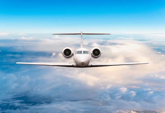 A private plane soars high above the clouds