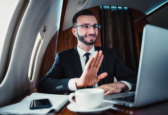 A man on a virtual call on a private jet