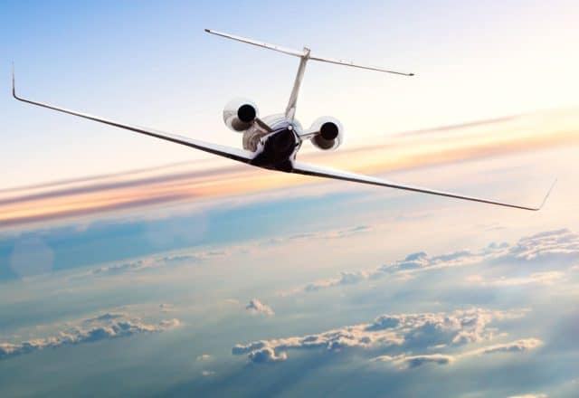 A private jet soars above the clouds.