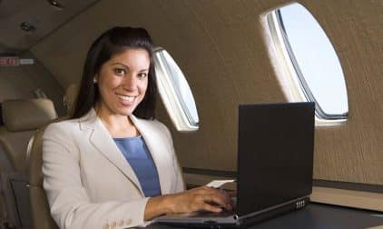 A business traveler uses a laptop on a private jet.