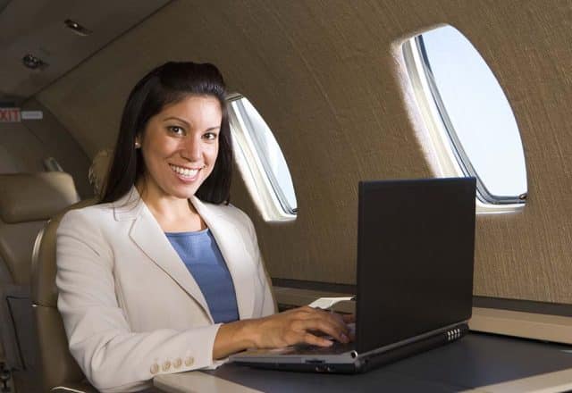 A business traveler uses a laptop on a private jet.