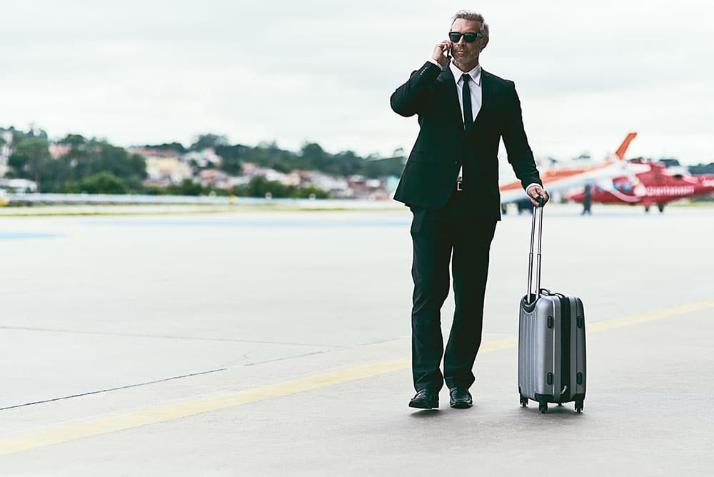 A businessman on a tarmac with private jets