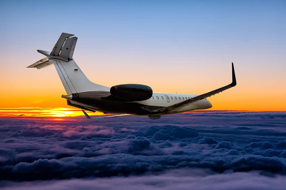 A private jet flying at sunset