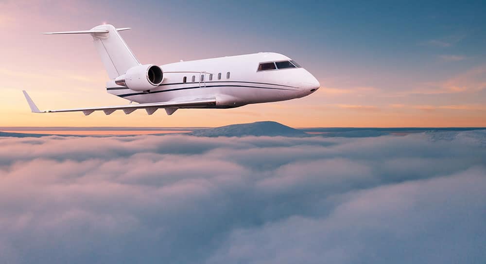 A private jet flies above the clouds.