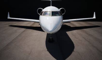 A close-up view of a private jet emerging from its hangar.