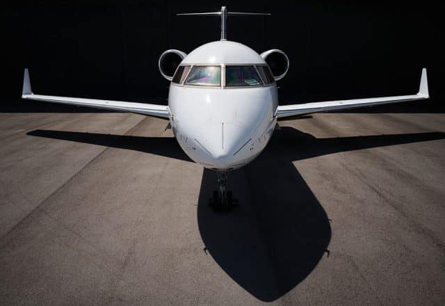 A close-up view of a private jet emerging from its hangar.