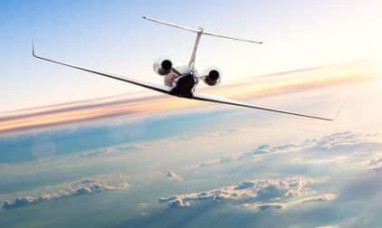 A private jet soars toward the horizon.